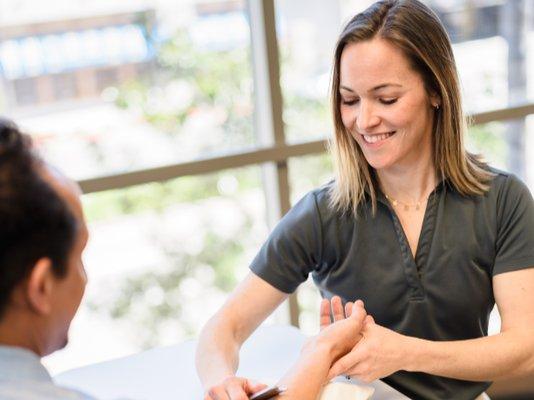 Therapist using the IASTM technique to a patient