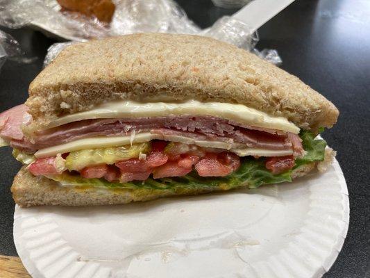 Ham and provolone sandwich on freshly baked honey oat bread with mayo, mustard, lettuce, tomato, pickles and banana peppers.