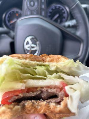 Underneath the giant lettuce, onion, and tomato is a little piece of beef