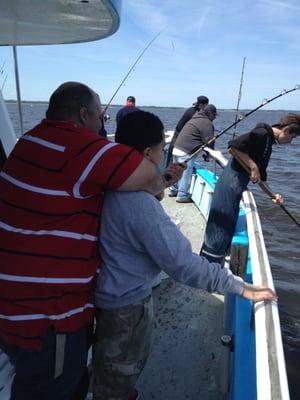 helpful staff member helps to retrieve fish from water