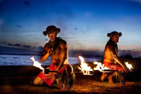 Hawaiian poi dancers spin fire on a sunset beach. Join us for a Ho`olaule`a!