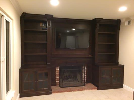 Custom entertainment wall made with cherry wood and a dark finish.