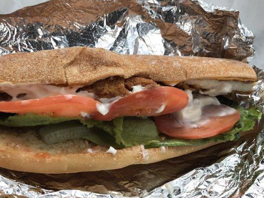 Crispy chicken sandwich with lettuce, tomato, and mayo