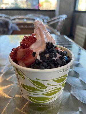 Strawberry frozen yogurt topped with fresh strawberries, chocolate chips and mini mnms