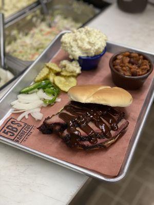 Beef brisket sandwich combo meal with potato salad and baked beans