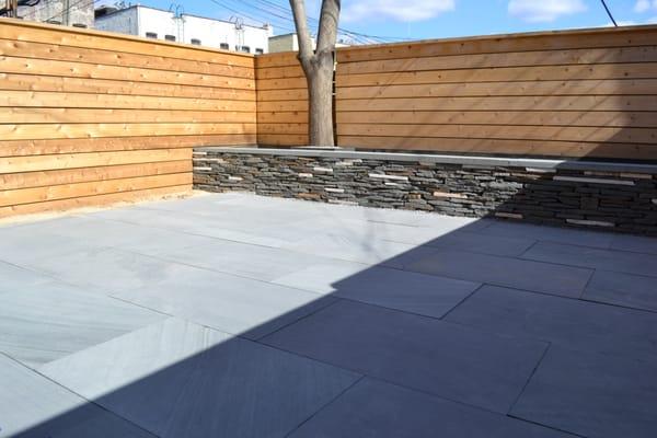 Natural Stone Pavers and Dry-laid stone walls. Also pictures is a cedar fence.