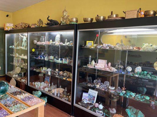 Display cases of jewelry , books , crystals , singing bowls