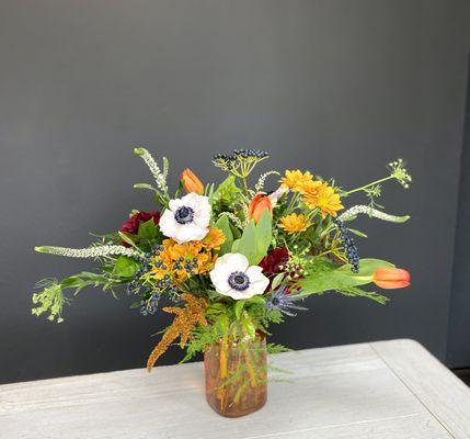 Fun and youthful flower arrangement of tulips, anemones, mums and berries. Delivery to Kent State University.