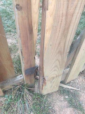 Fence door with wood broken off hinge.