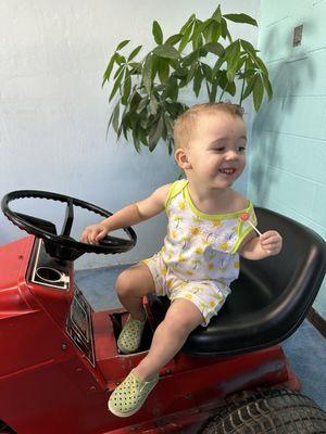 Playing on the tractor in the area with all the toys