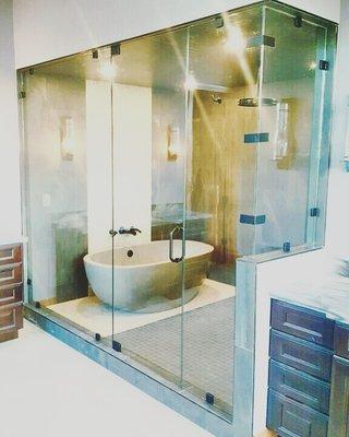 rain shower head and soaking tub inside large seamless shower enclosure