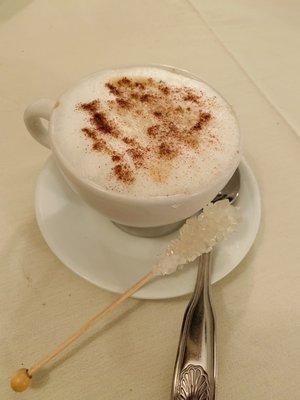 Cappuccino with sugar stick.