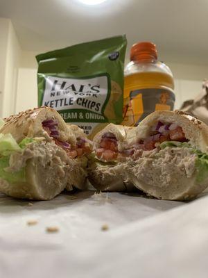 Tuna salad sandwich with lettuce, tomato and red onions on a sesame bagel!!!