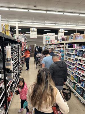 The line in front of me, waiting for the sole checker. The line continued behind me down the rest of the aisle. See pic.