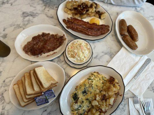 Corn beef hash, spinach and feta cheese omelette, sausages, eggs with bacon, cole slaw,