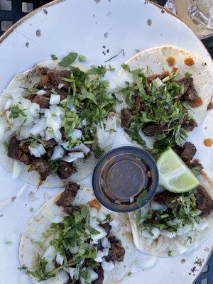 Carne asada street tacos with cilantro and onions, hot sauce is hot!