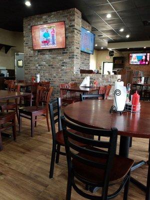 Tables and chairs in the restaurant and the soda machine.