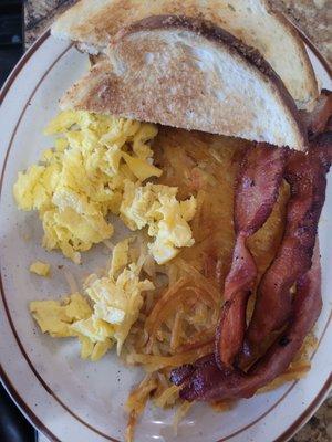 Standard breakfast of scrambled eggs, bacon, hash browns and toast