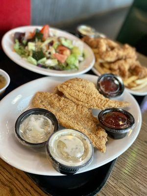 Catfish, chicken strips, salad and fries