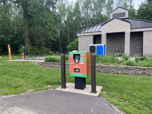 Pay machine, bathrooms behind, bike fix station on right