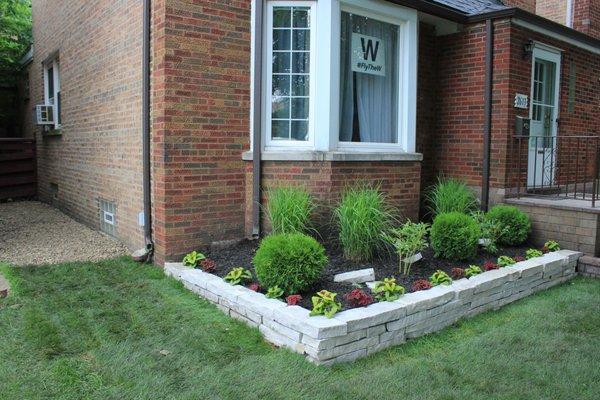 After Landscaping:
 Objective: New sod installed, Natural cut stone flower bed installed among new plants for a new summer season.