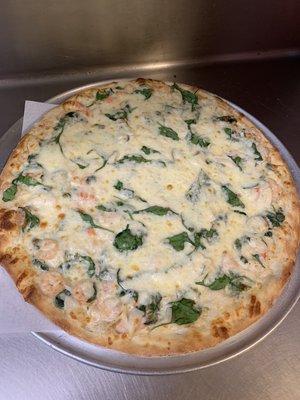 White pizza with shrimp and spinach.