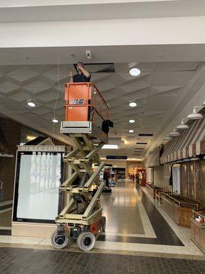 Installing the ceiling mounted motion detectors @ the Washington square mall