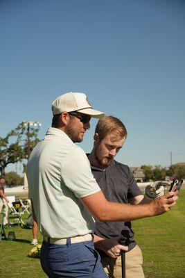 Coach Dawson Frye going over a video analysis during a golf lesson.