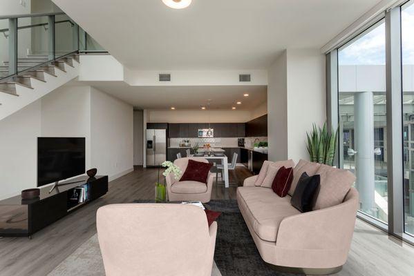 Spacious open concept living room with floor to ceiling windows for natural light, and wood style plank flooring, at Lantower River Landing.