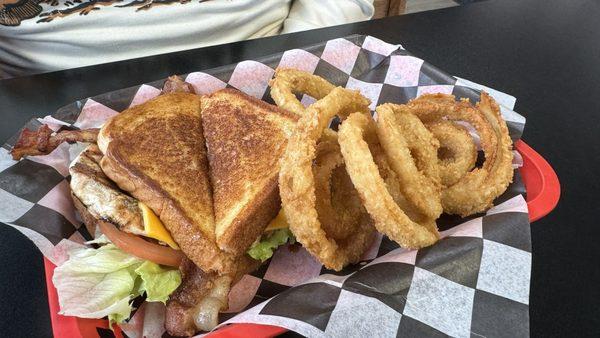 Grilled chicken club sandwich with hand breaded onion rings