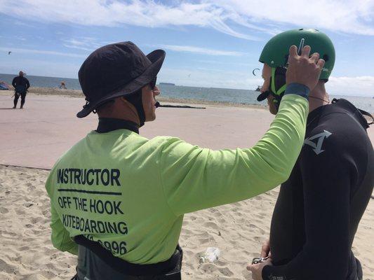 Instructor Jessie helps a student adjust his safety helmet.