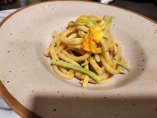 Squash bucatini accented with squash blossoms,