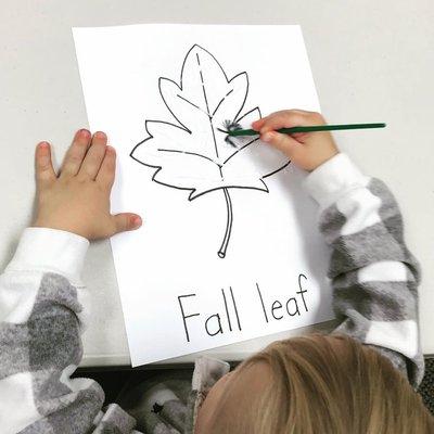 Painting with glue to make colored sparkly leaves.