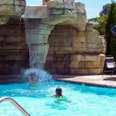 Outdoor pool is complete with a waterfall and whirlpool