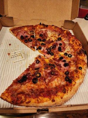 Pizza with pepperoni, ham, bacon and olivies.