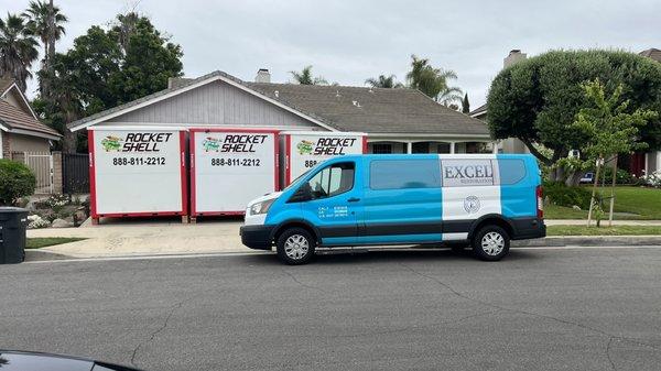 Excel Restoration van and three storage containers