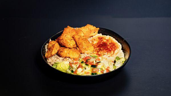 Swai Fish Hummus Bowl: Eight swai nuggets atop aromatic basmati rice, hummus, served with a mix of lettuce, cucumber & tomato.