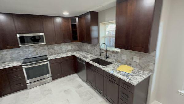 New kitchen, cabinetry along with countertops, backsplash, flooring, and appliances