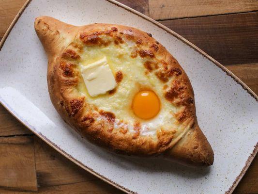 Adjaruli Khachapuri (Cheeseboat) Georgian bread filled with a cheese, egg, butter.