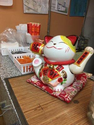 Nice condiment area on the counter with CUTE lucky cat!