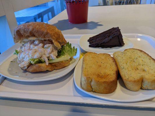 Shrimp salad sandwich (left), garlic bread (right), chocolate cake (back)