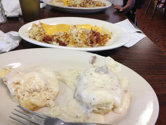 Biscuits and gravy and hash browns with cheese