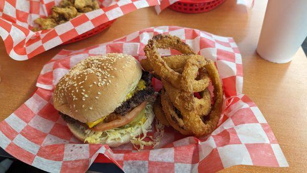 Cheeseburger with lettuce, tomatoes, and onion rings