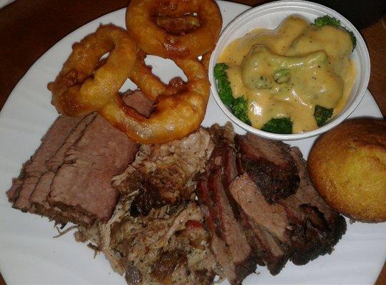 Three meat combo tri tip brisket and pulled pork with onion rings and cheese topped broccoli with a muffin and cinnamon butter