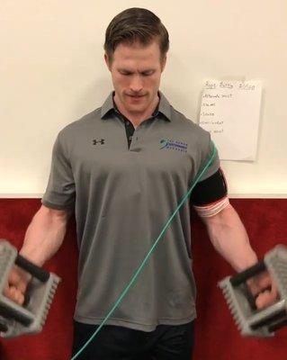 Nick using blood flow restriction to strengthen his arms.