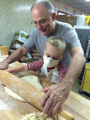 Dan(owner) teaching his grandson how to roll out donut dough