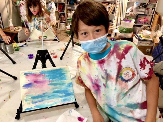 2021 RAZ Art Camper displays his design work on a real T-shirt & zipper mobile device pouch he can use! Campers will make these each week!