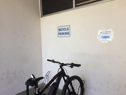 Entrance and line for Non-Appointments are in the opposite direction of this sign, which leads people into parked bikes or a wall!