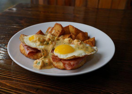 Bayou Benedict - toasted biscuit topped with ham, eggs cooked your way, topped with crawfish cream sauce and served with Cajun potatoes