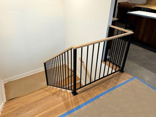 Interior railing with vertical bars and wooden top